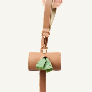 Powder pink leather dog waste bag holder attached to matching leash