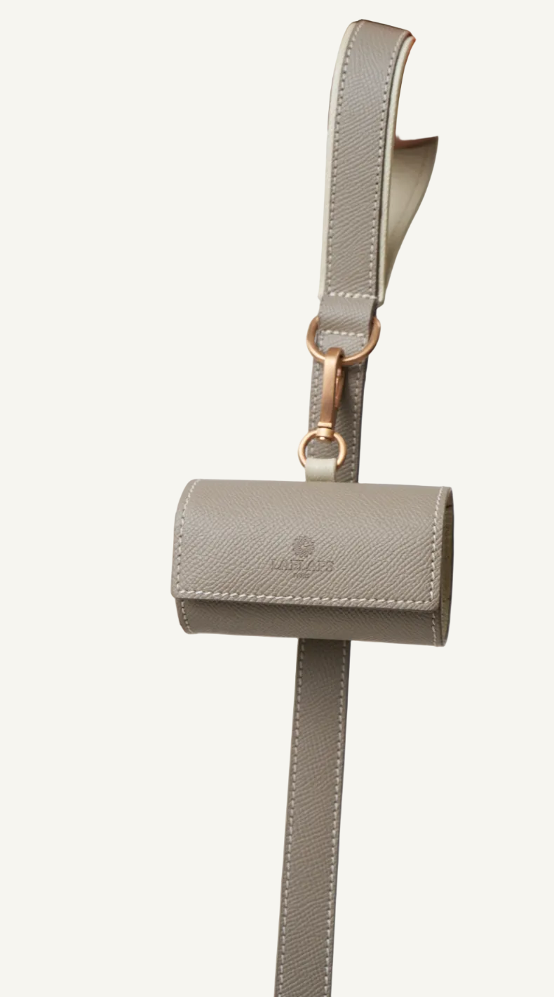 Orange leather leash with camel accent and matching orange waste bag holder by Laelaps Paris 