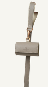 Orange leather leash with camel accent and matching orange waste bag holder by Laelaps Paris 