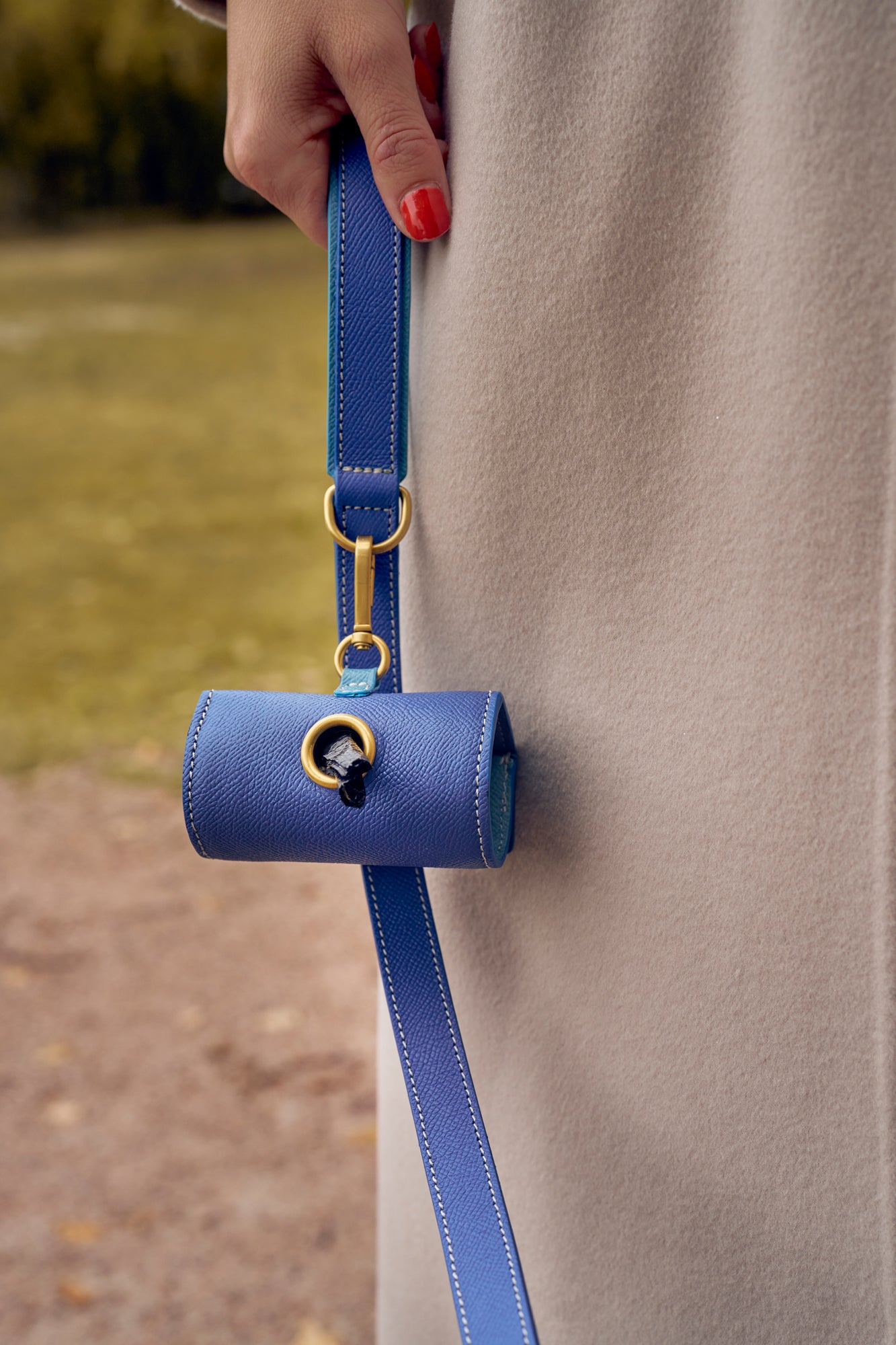 Blue leather waste bag holder with matching blue leather leash by Laelaps Paris
