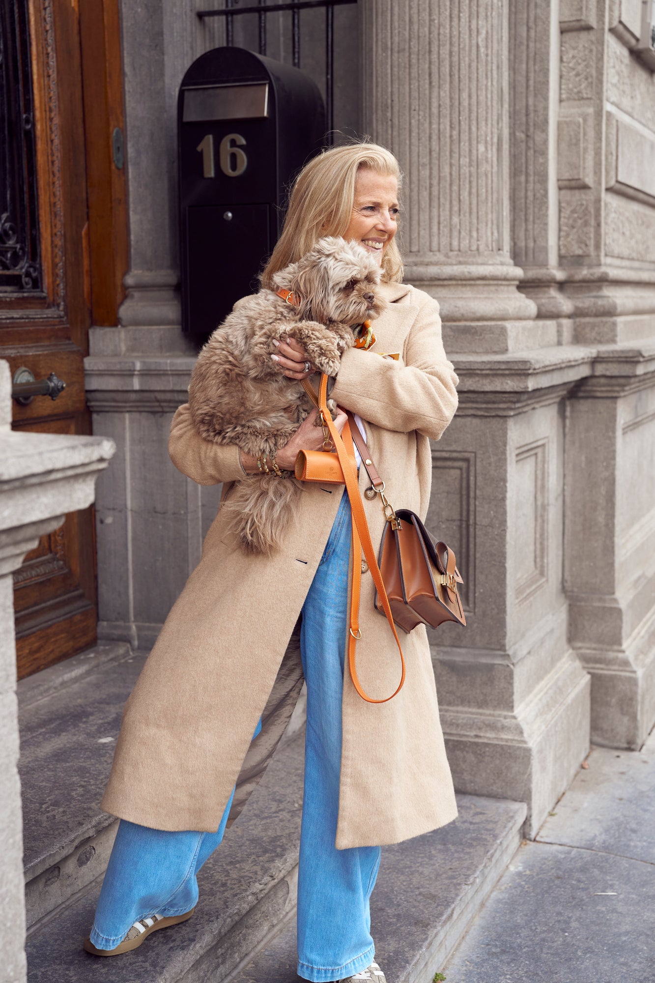 Lady with cure dog, wearing an orange collar and leash set from Laelaps Paris 