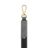 Close-up of black leather dog leash with gold clasp